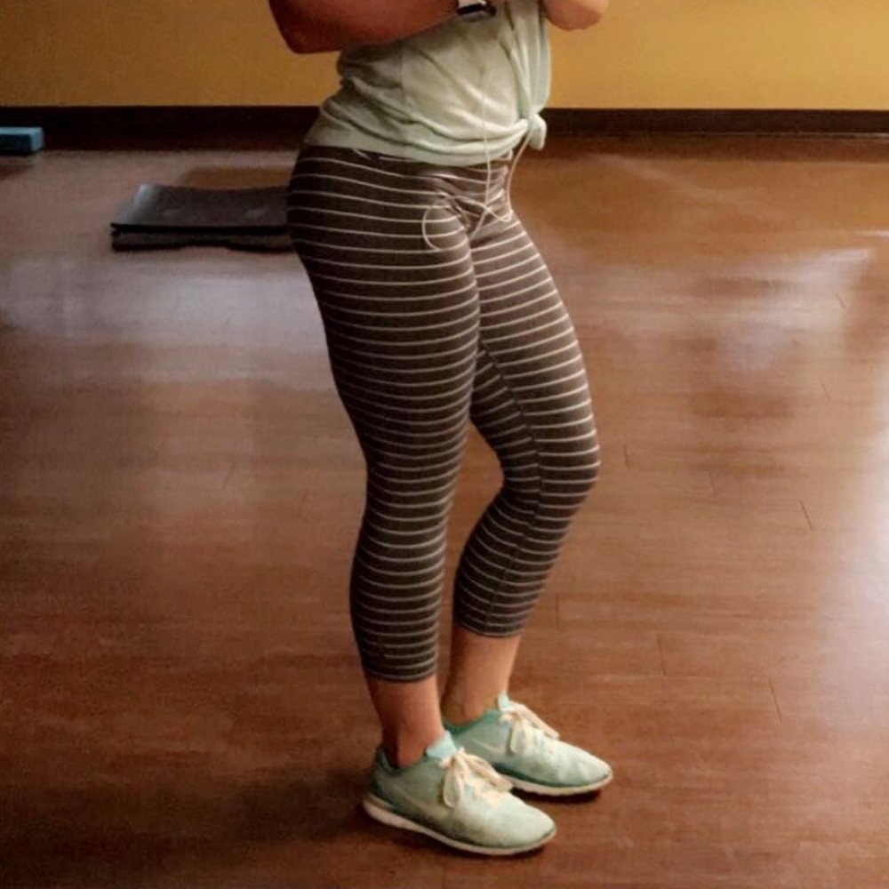 Grey cropped leggings with white stripes.